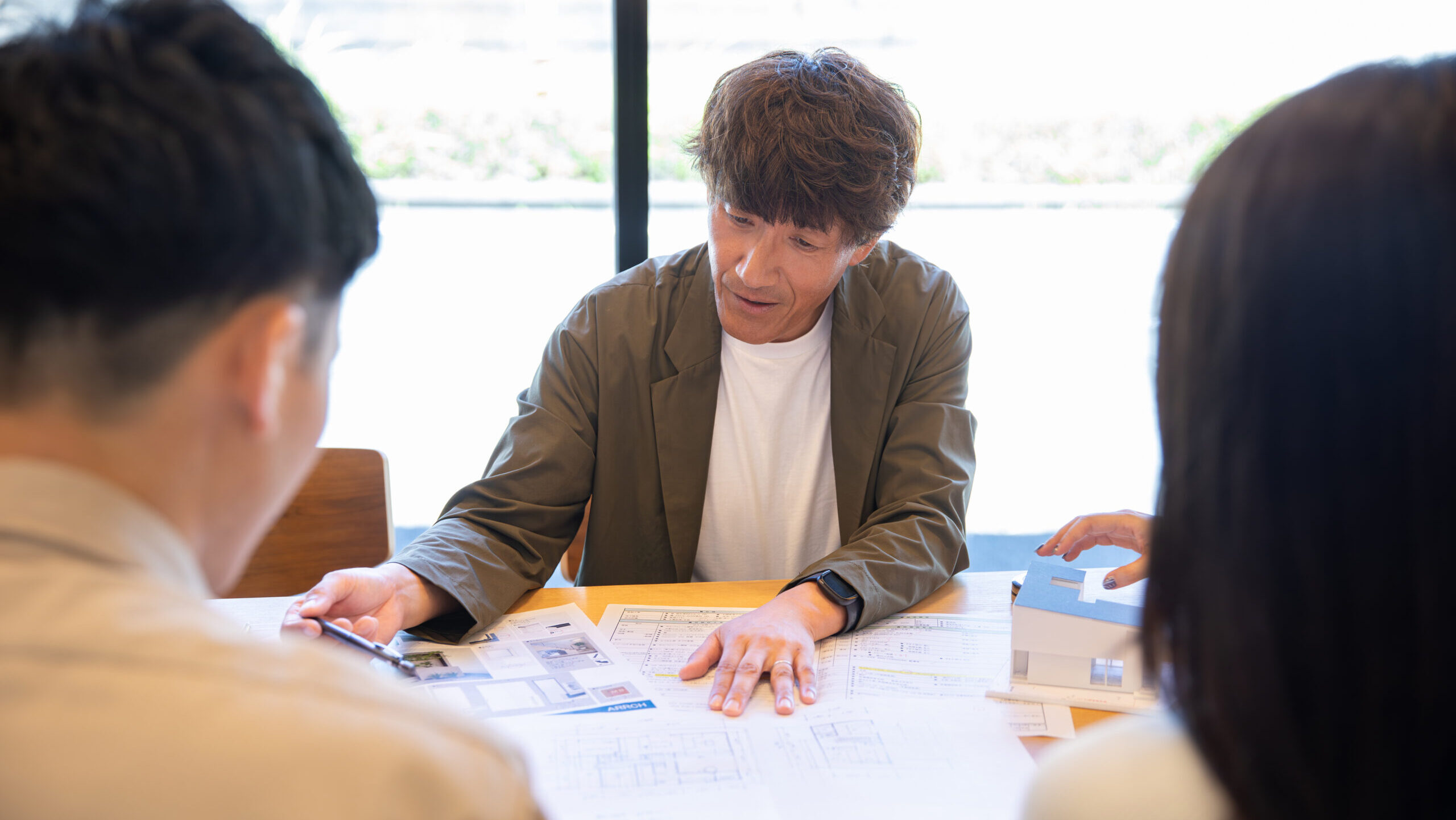 建築家がお客様と間取り設計と予算のバランスについて打ち合わせをしている様子