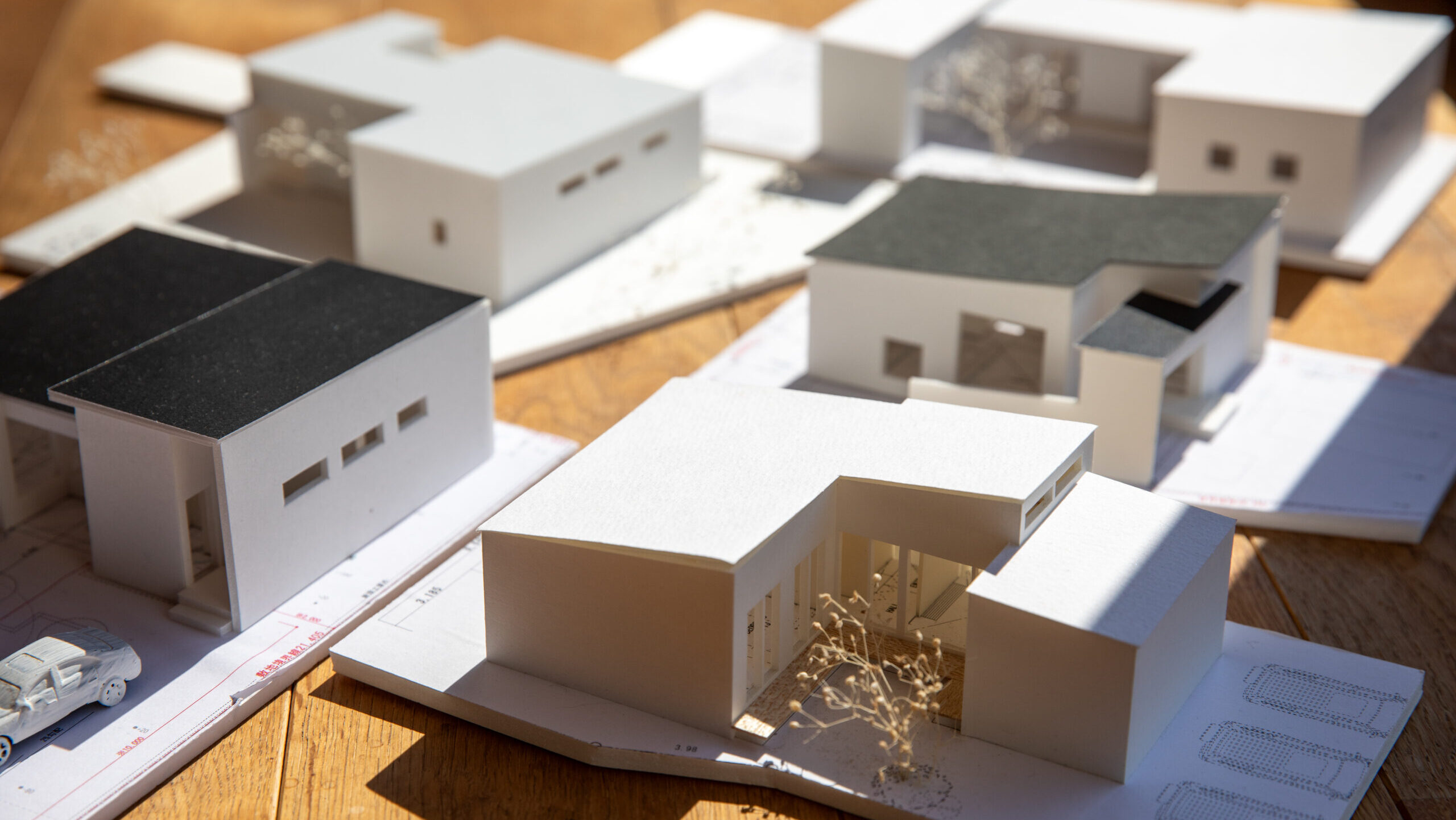 坪単価と建築費用の関係をイメージした注文住宅模型の写真